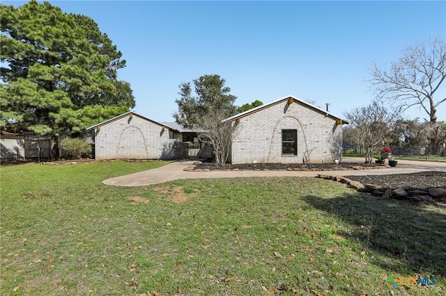 exterior space with brick siding and a yard