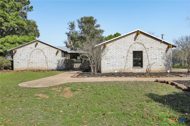 view of front facade featuring brick siding and a front lawn