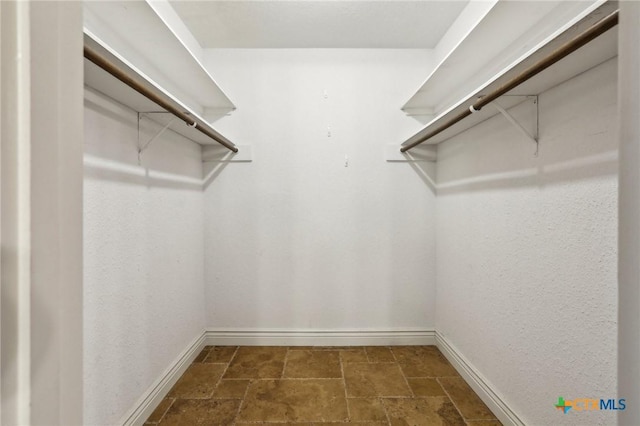 spacious closet with stone finish floor