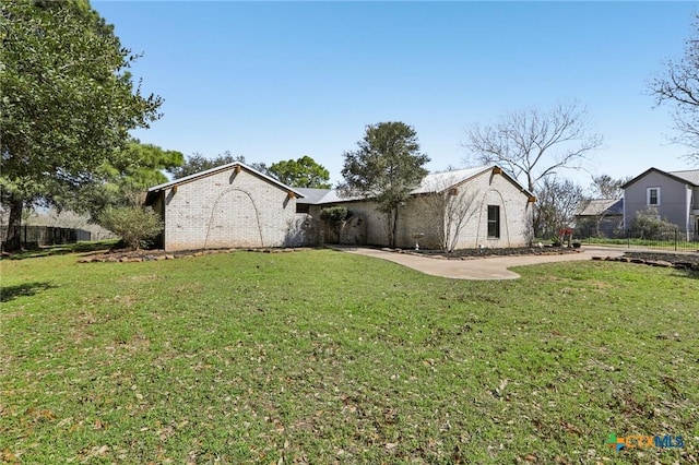view of front facade featuring fence, brick siding, and a front yard