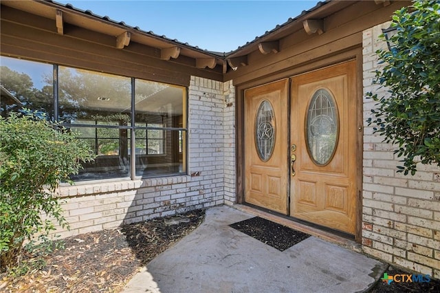 doorway to property with brick siding