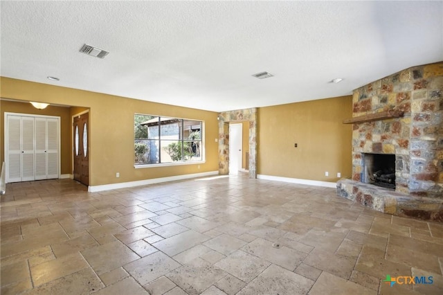 unfurnished living room with stone tile flooring, baseboards, a stone fireplace, and visible vents