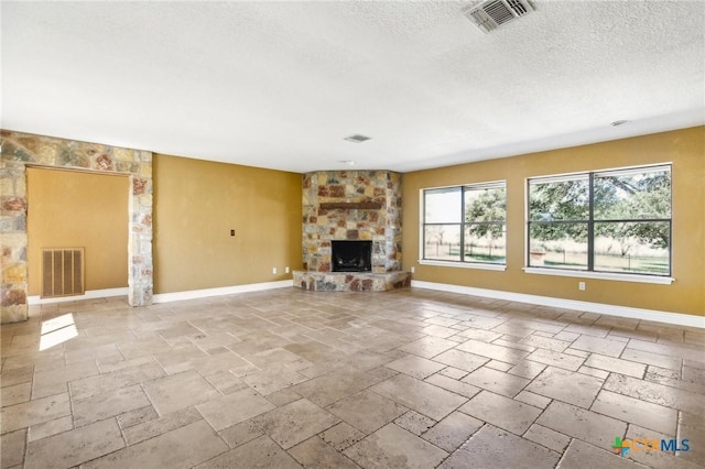 unfurnished living room featuring stone tile flooring, a stone fireplace, and visible vents