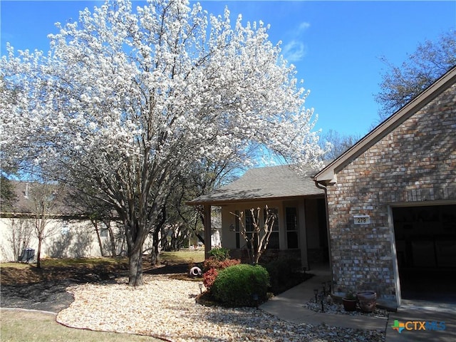 view of yard featuring a garage and covered porch