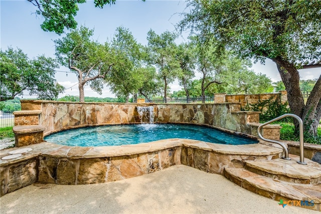 view of pool featuring pool water feature and a hot tub