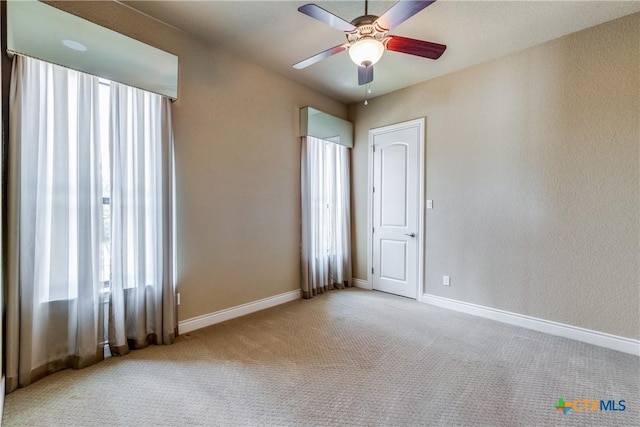 carpeted empty room featuring ceiling fan