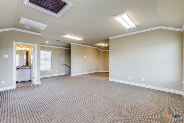 spare room with crown molding, carpet floors, and vaulted ceiling