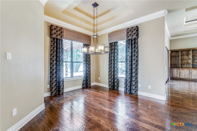 unfurnished dining area featuring dark hardwood / wood-style flooring, a tray ceiling, an inviting chandelier, and ornamental molding