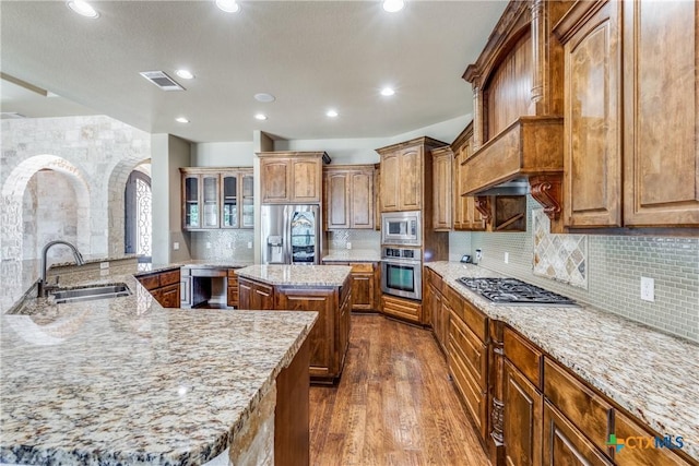 1027 Las Brisas Dr, Canyon Lake, TX 78133 - kitchen with appliances with stainless steel finishes, a large island with sink, a sink, dark wood-type flooring, and backsplash