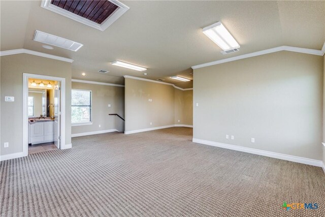 spare room with crown molding, carpet, and lofted ceiling