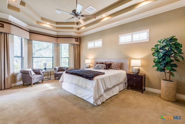 carpeted bedroom with a tray ceiling, ceiling fan, and ornamental molding