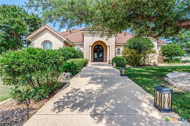 1027 Las Brisas Dr, Canyon Lake, TX 78133 - mediterranean / spanish-style home with french doors, stucco siding, and a tiled roof