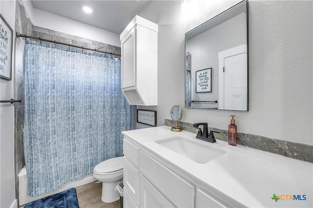 bathroom with wood finished floors, vanity, toilet, and shower / bathtub combination with curtain