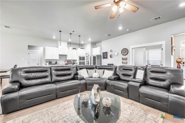 living room with light wood-style floors, visible vents, and recessed lighting