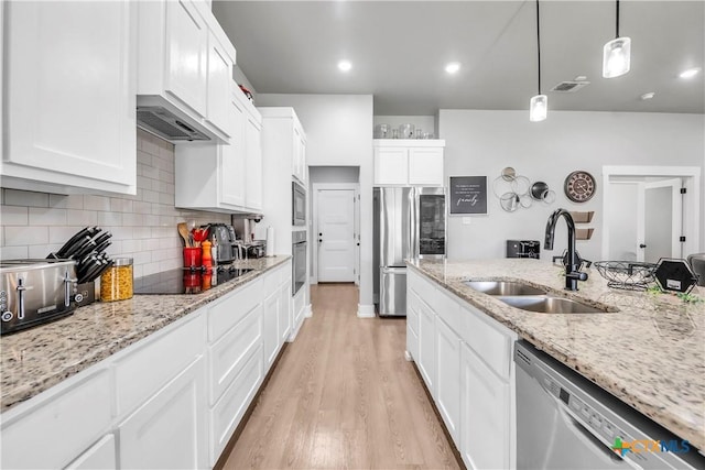 kitchen featuring backsplash, light wood-style flooring, white cabinets, a sink, and black appliances