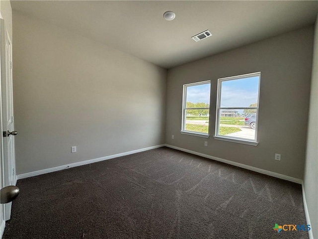 837 Swallow Dr, Palacios, TX 77465 - empty room with baseboards, dark colored carpet, and visible vents