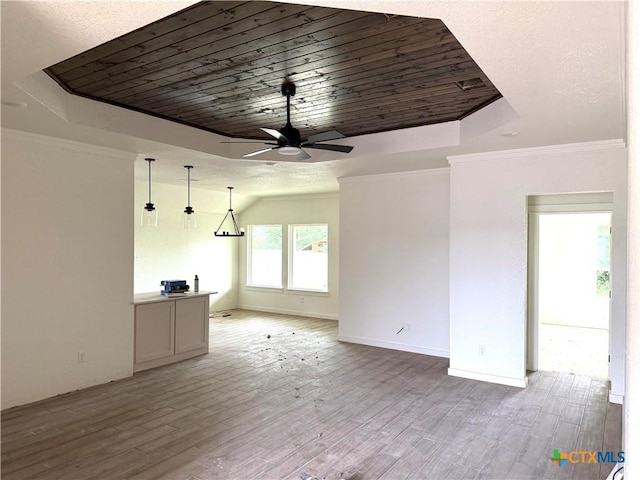 3804 Oglala Trl, Temple, TX 76502 - unfurnished living room with ceiling fan, a tray ceiling, wooden ceiling, light wood-type flooring, and crown molding