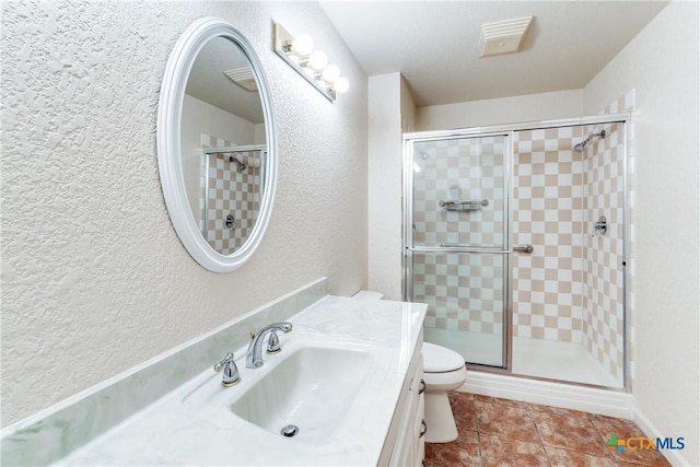 832 Saint James, Seguin, TX 78155 - bathroom featuring a textured wall, vanity, a shower stall, toilet, and tile patterned flooring