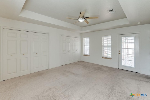 832 Saint James, Seguin, TX 78155 - unfurnished bedroom with a tray ceiling, carpet, two closets, and ceiling fan