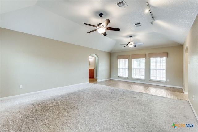 832 Saint James, Seguin, TX 78155 - unfurnished room with carpet, rail lighting, lofted ceiling, arched walkways, and a ceiling fan