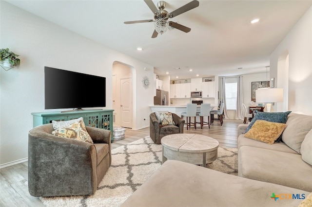 401 Thunder Valley Trl, Georgetown, TX 78626 - living room featuring arched walkways, light wood-style flooring, and ceiling fan