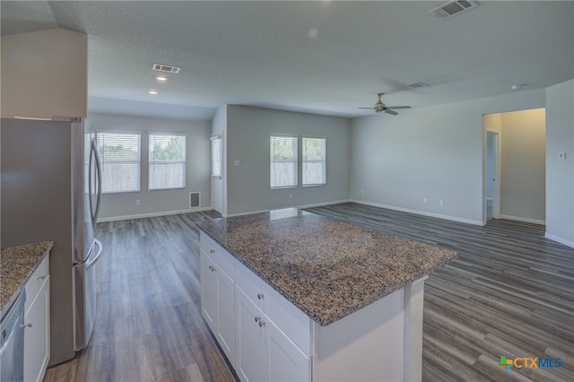 kitchen featuring a wealth of natural light, appliances with stainless steel finishes, dark hardwood / wood-style floors, and white cabinets