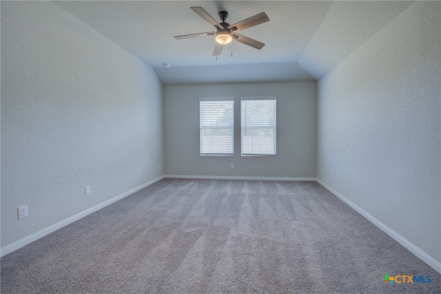 empty room featuring ceiling fan, carpet flooring, and vaulted ceiling