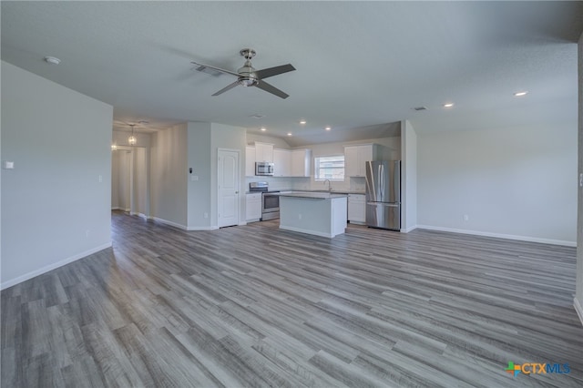 unfurnished living room featuring light hardwood / wood-style floors, ceiling fan, and sink