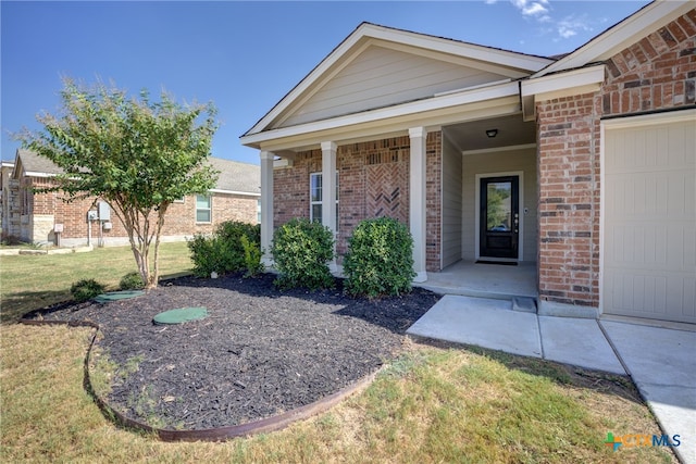 entrance to property featuring a garage and a yard