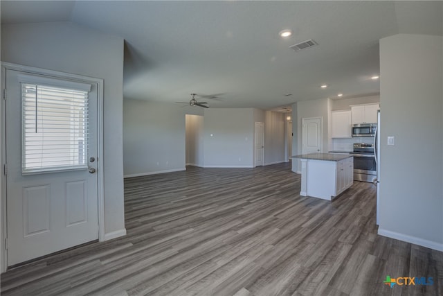 unfurnished living room with hardwood / wood-style floors, ceiling fan, and vaulted ceiling