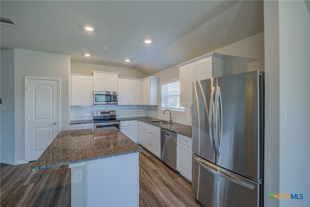 kitchen featuring stainless steel appliances, white cabinetry, a kitchen island, and hardwood / wood-style floors