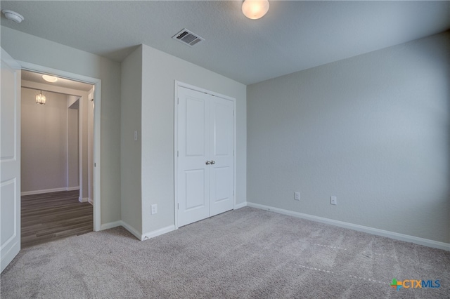 unfurnished bedroom with light carpet and a closet