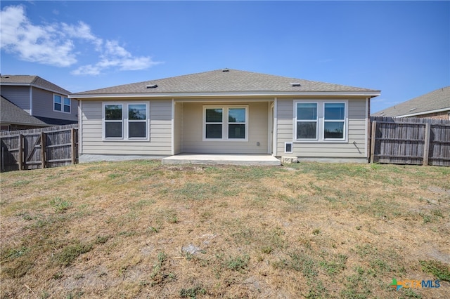 rear view of house with a lawn and a patio