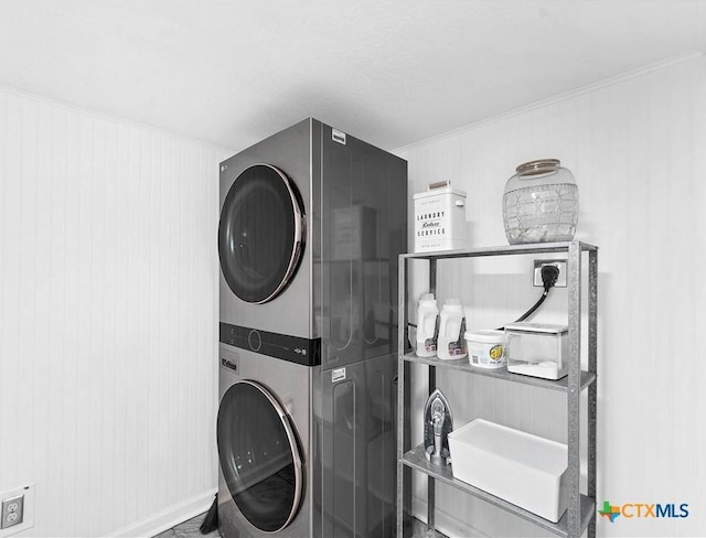 washroom with laundry area, crown molding, and stacked washer and clothes dryer