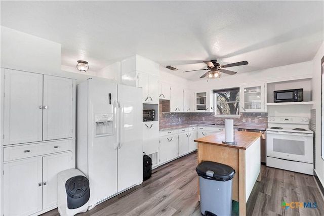 kitchen featuring white appliances, backsplash, wood finished floors, and white cabinetry