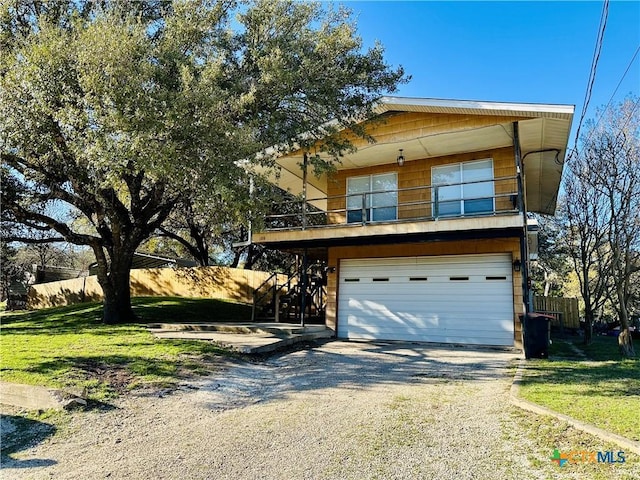 view of front facade with a front lawn, fence, a garage, a balcony, and driveway