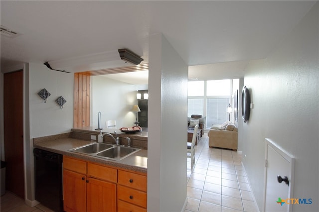 kitchen featuring dishwasher, sink, and light tile patterned flooring