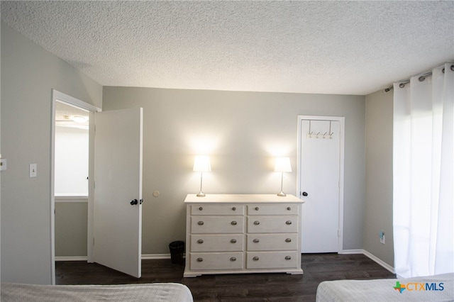 unfurnished bedroom with dark hardwood / wood-style floors and a textured ceiling