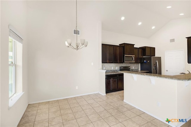 6402 Ambrose Cir, Temple, TX 76502 - kitchen with stainless steel appliances, high vaulted ceiling, a chandelier, decorative backsplash, and light stone countertops
