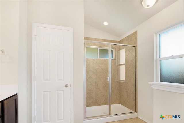 bathroom featuring lofted ceiling, vanity, tile patterned flooring, and a shower with door