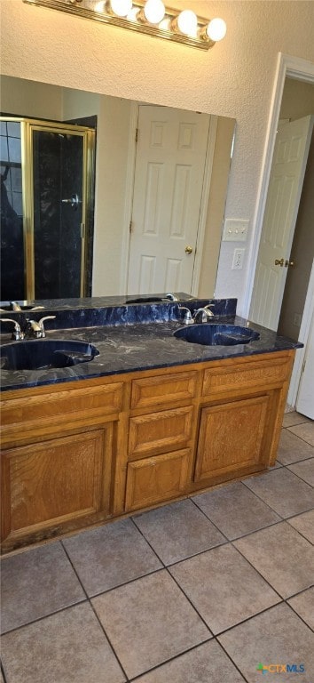 bathroom with vanity, tile patterned flooring, and a shower with door