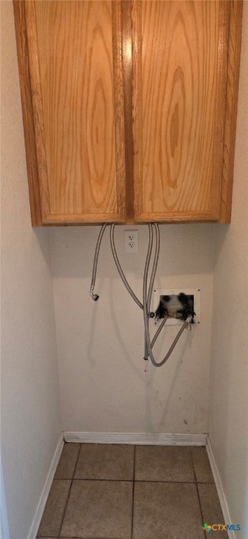 laundry area featuring washer hookup, cabinets, and tile patterned floors