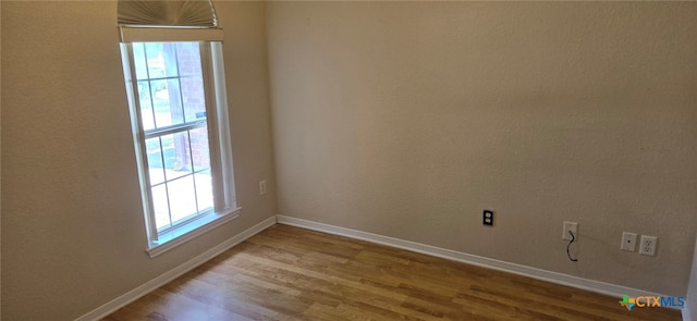 spare room with light wood-type flooring and a healthy amount of sunlight