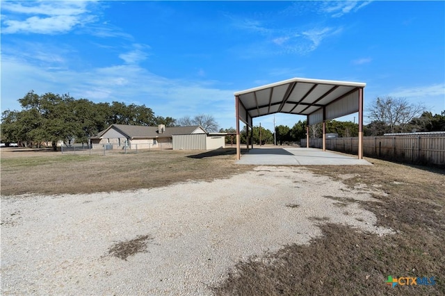 view of yard featuring fence and a carport