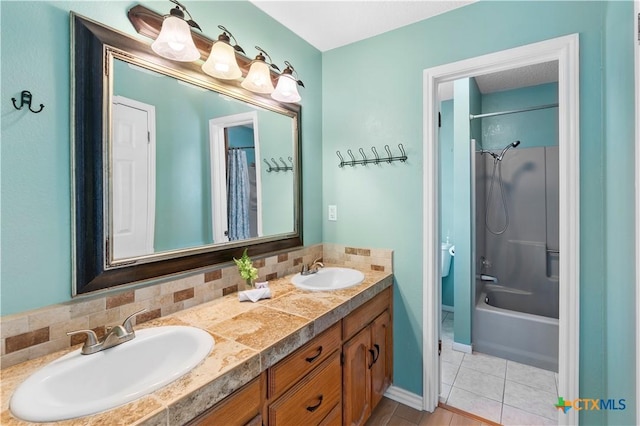 bathroom featuring double vanity, tile patterned flooring, tasteful backsplash, and a sink