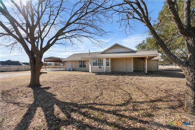 view of front of home with an attached carport and fence