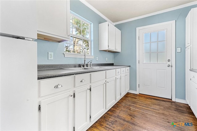 kitchen featuring ornamental molding, sink, white cabinets, and dark hardwood / wood-style flooring