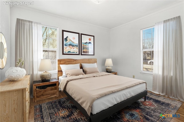 bedroom with crown molding and hardwood / wood-style flooring