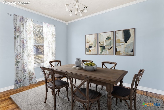 dining room with crown molding, hardwood / wood-style floors, a textured ceiling, and an inviting chandelier