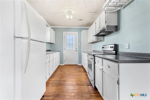 kitchen with white refrigerator, white cabinets, and electric stove